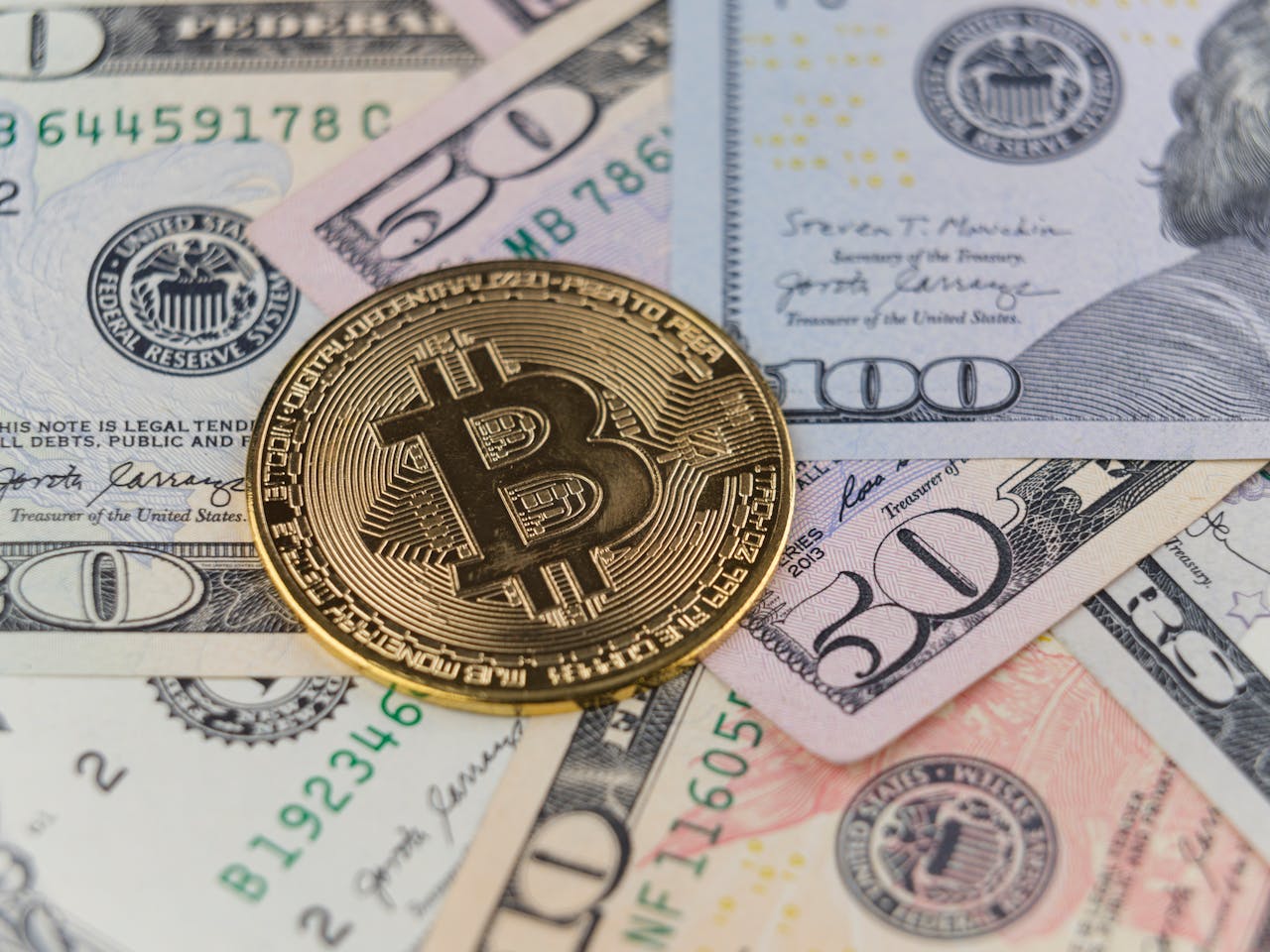 Close-up of a Bitcoin coin on US dollar banknotes, symbolizing cryptocurrency and traditional finance.