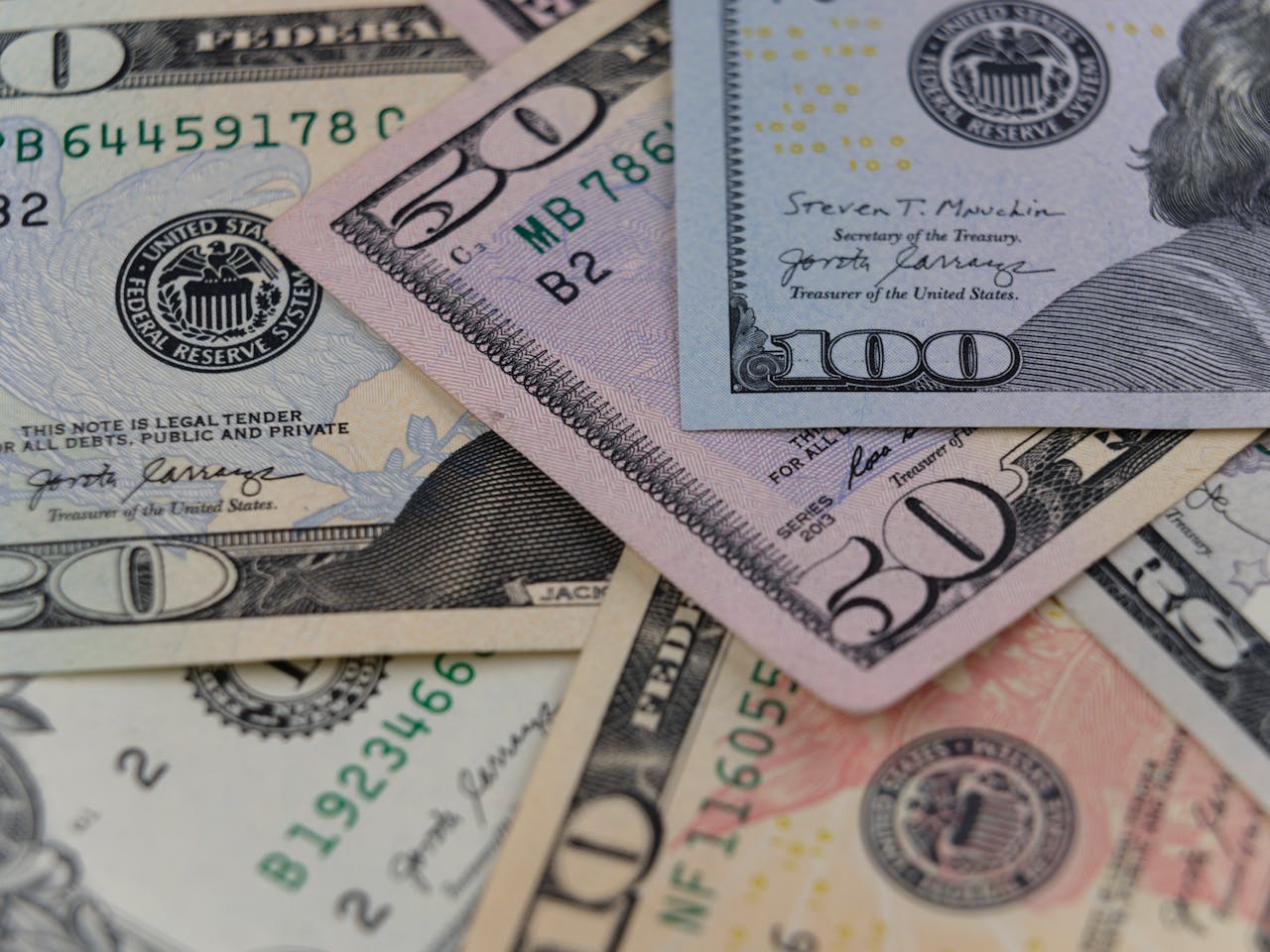 Detailed view of US currency, including $50 and $100 bills, symbolizing finance and economy.